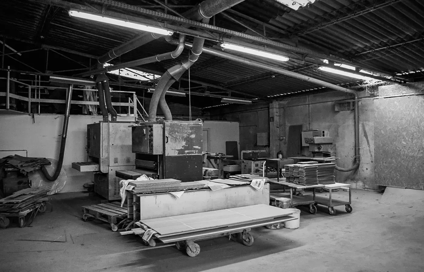 Ambiente industrial de uma fábrica de mobiliário, com máquinas, materiais e bancadas de trabalho